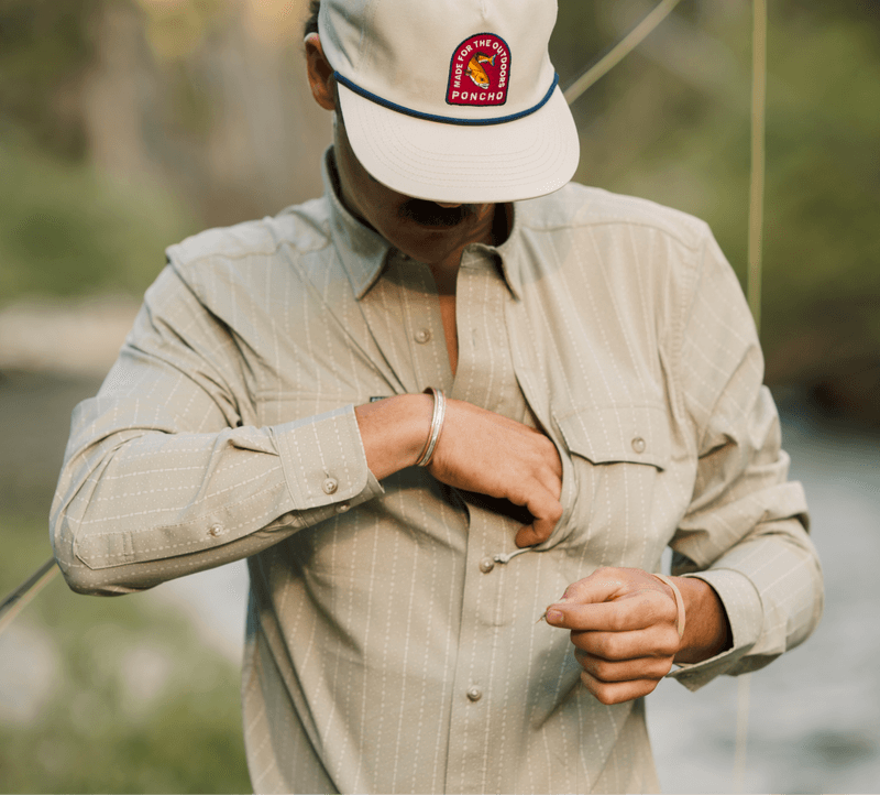 Man in tan shirt reaching n zipper pocket